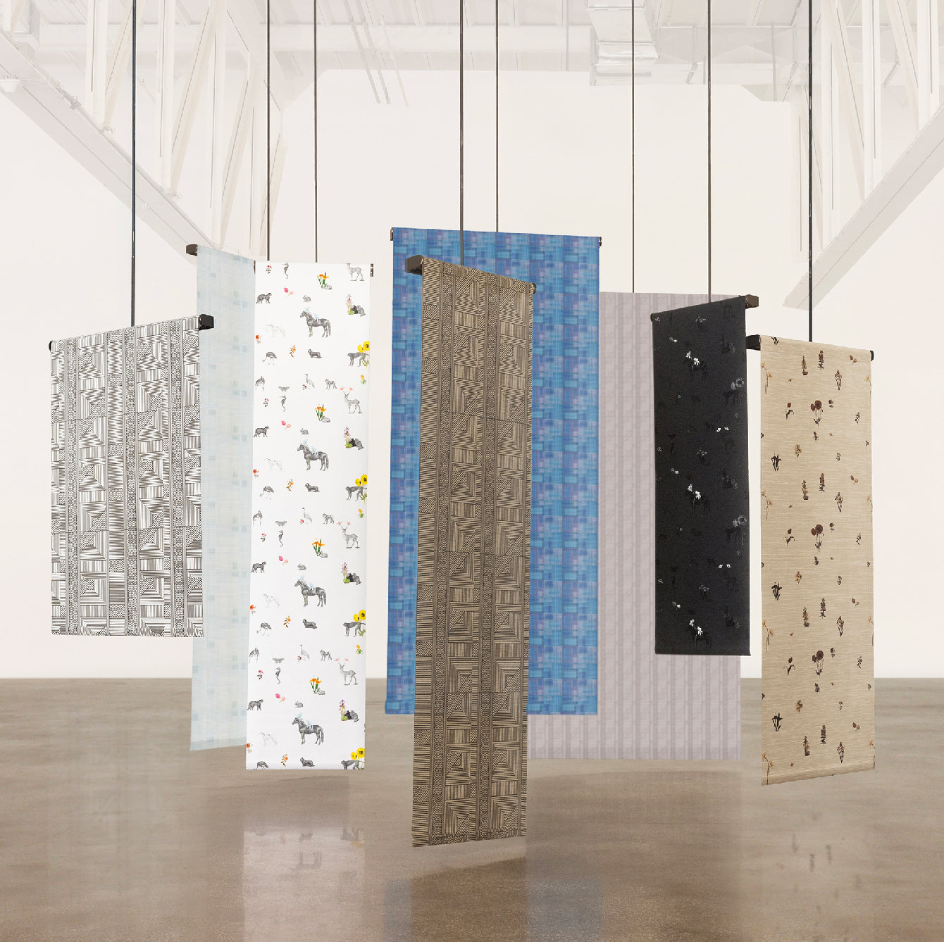 Collection of patterned window treatments and window shade by The Shade Store x Mimi Plange displayed against a white wall.