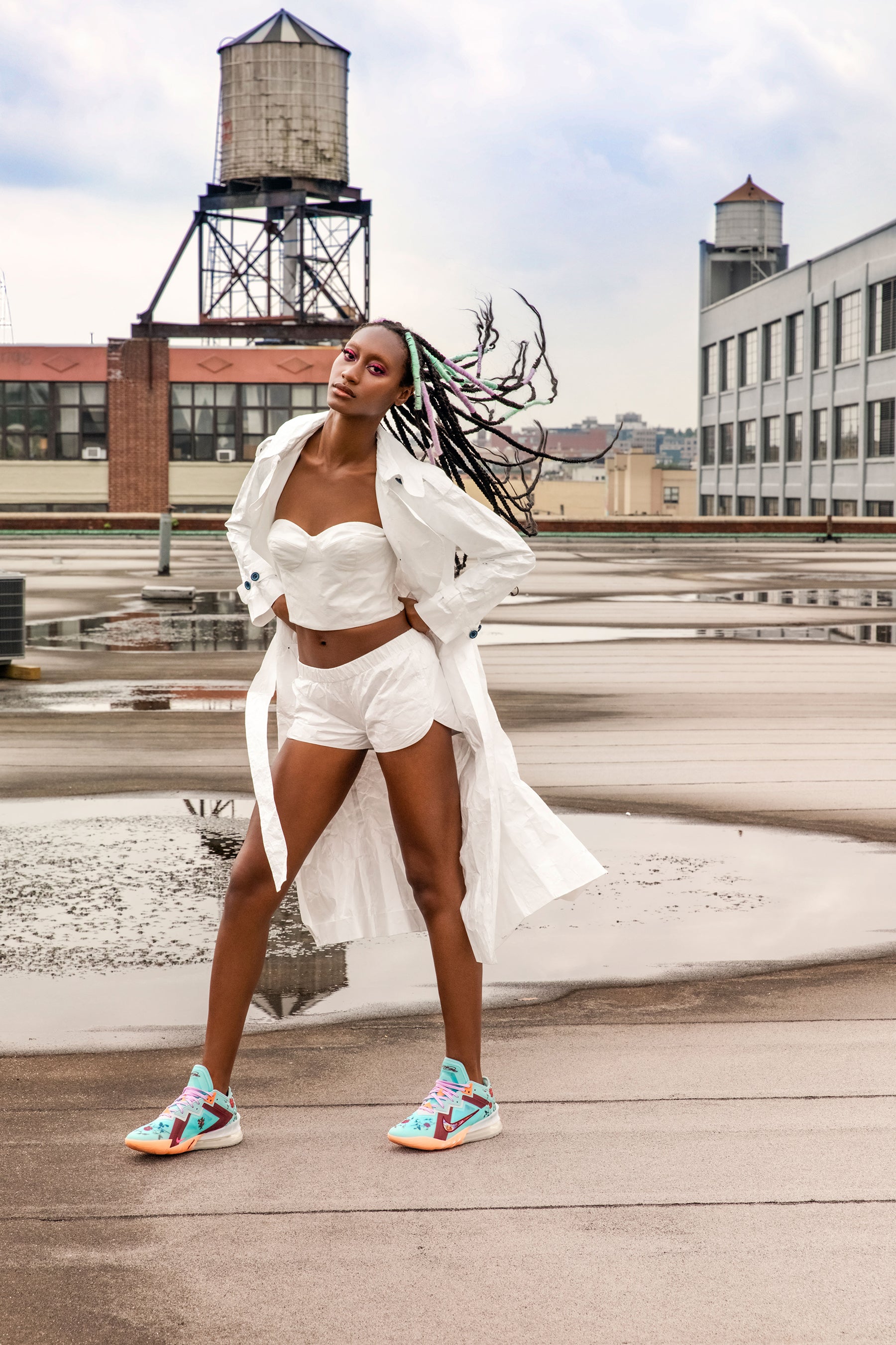 A models braids blow in the wind while she wears a tyvek outfit of bustier, shorts and tyvek trenchcoat by Mimi Plange