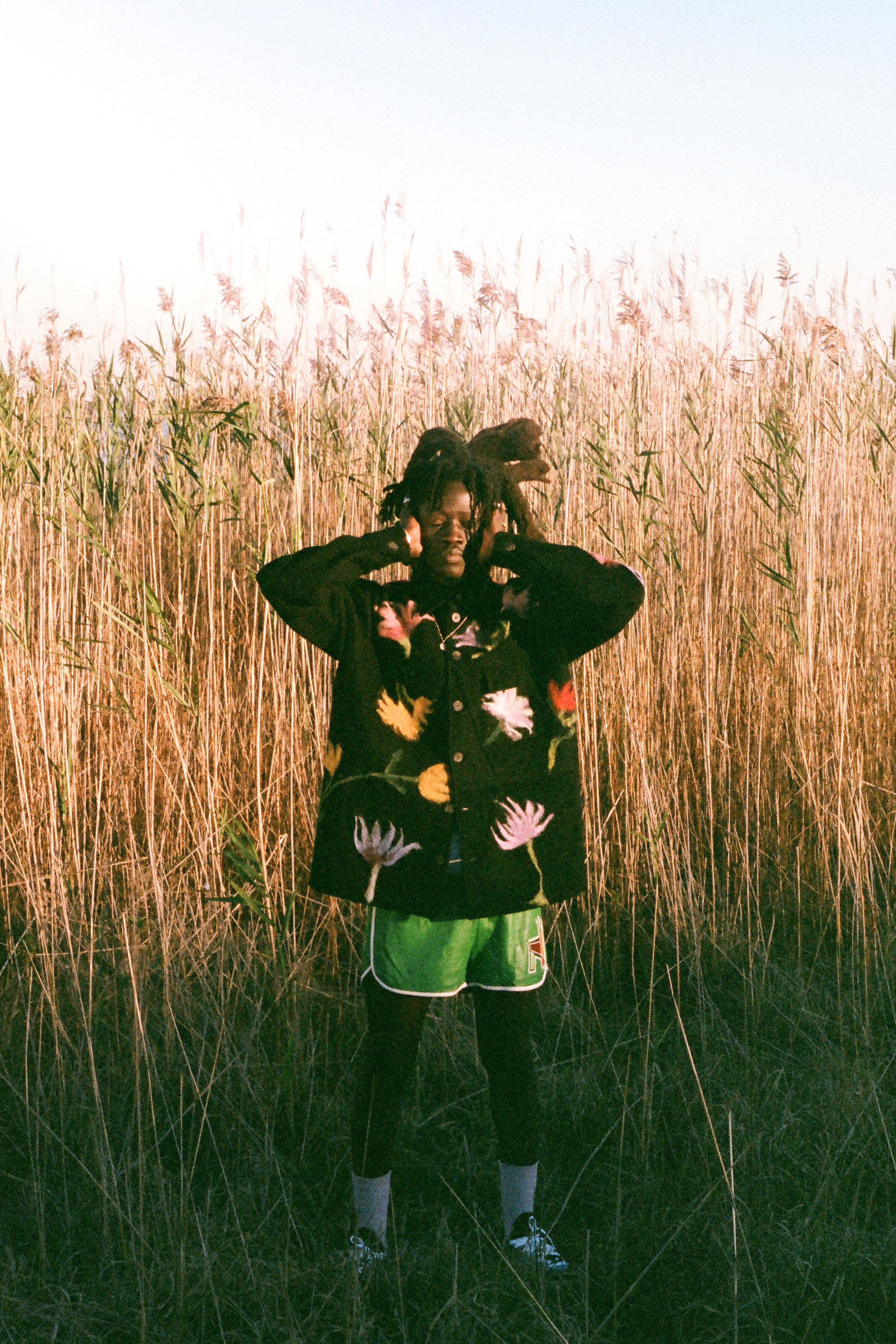 Person wearing a colorful jacket with floral patterns in a field