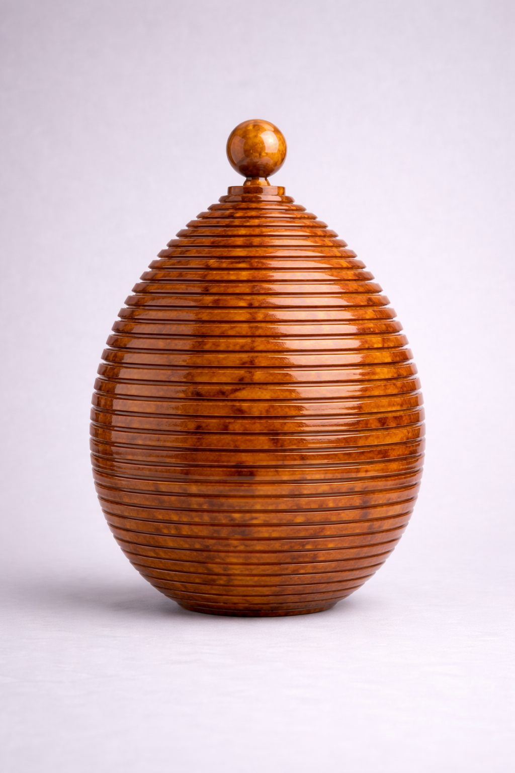 Tortoise vase with a textured surface and spherical top on a white background