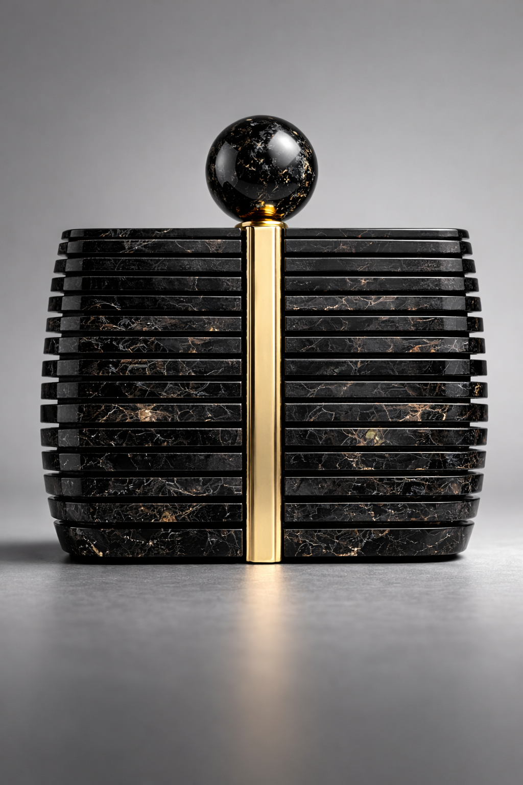 Black marble clutch with gold accent on a gray background