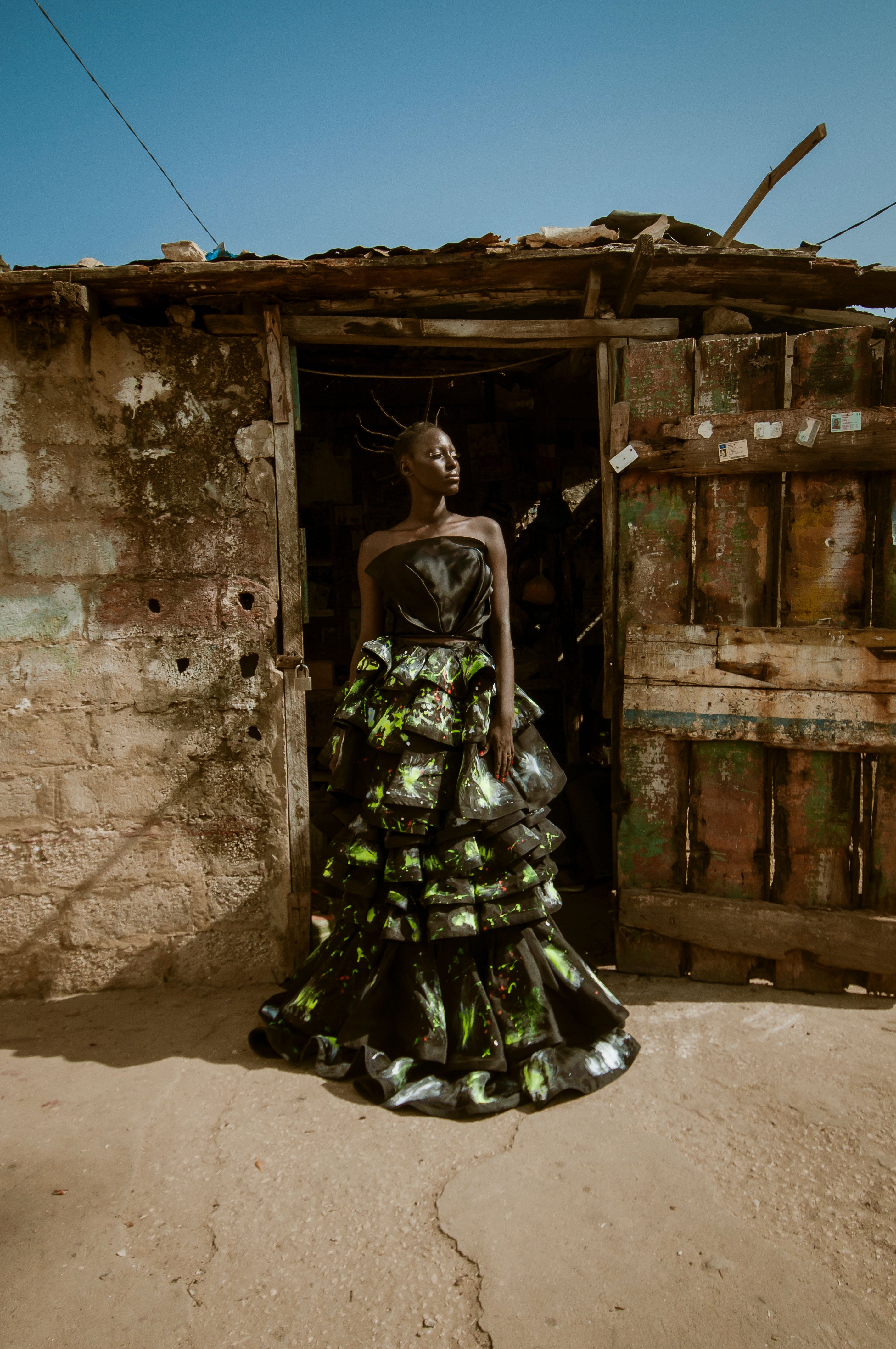 A model from Dakar Senegal, wears a hand-painted black silk ruffle gown by designer Mimi Plange
