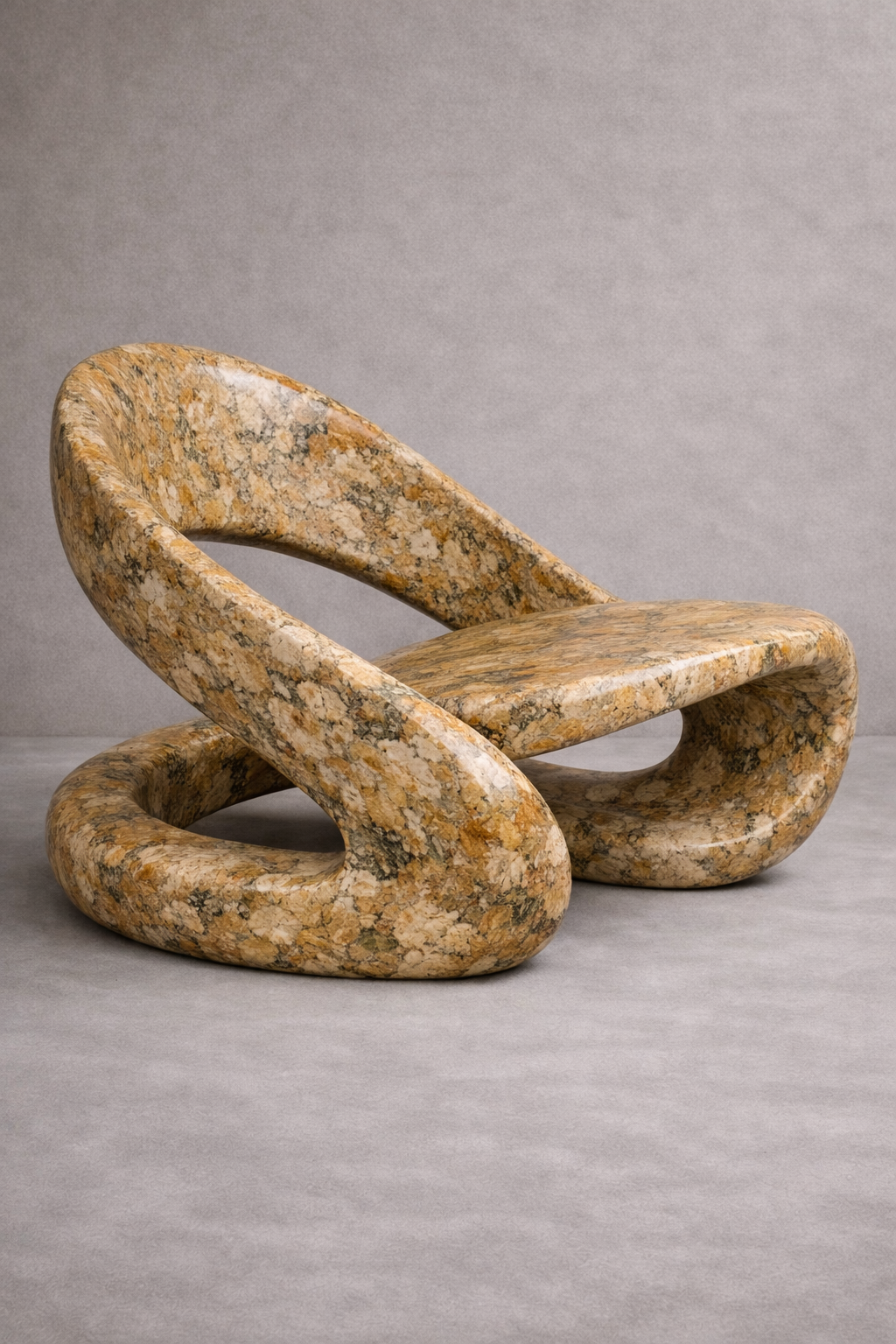 Stone curved chair with a natural, textured surface on a gray background