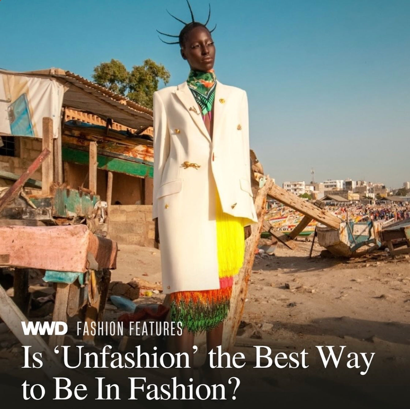 Model in Dakar Senegal wears a stylish outfit by designer Mimi Plange featured in WWD with a backdrop of a cityscape and makeshift structures.