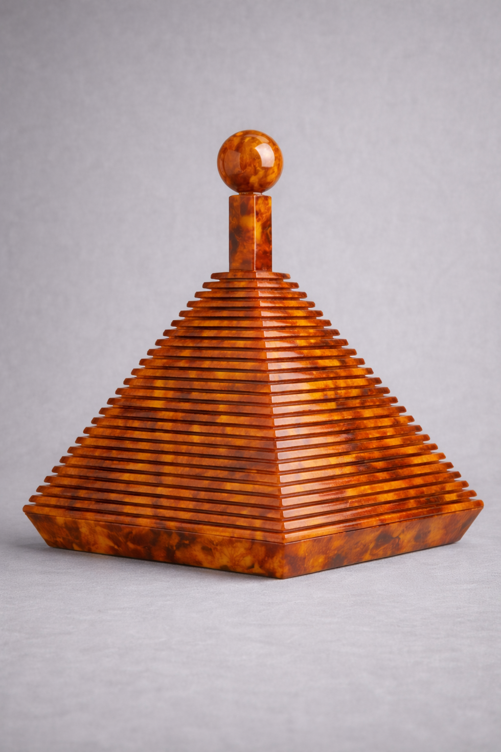 Tortoise shell pyramid-shaped decorative object on a gray background