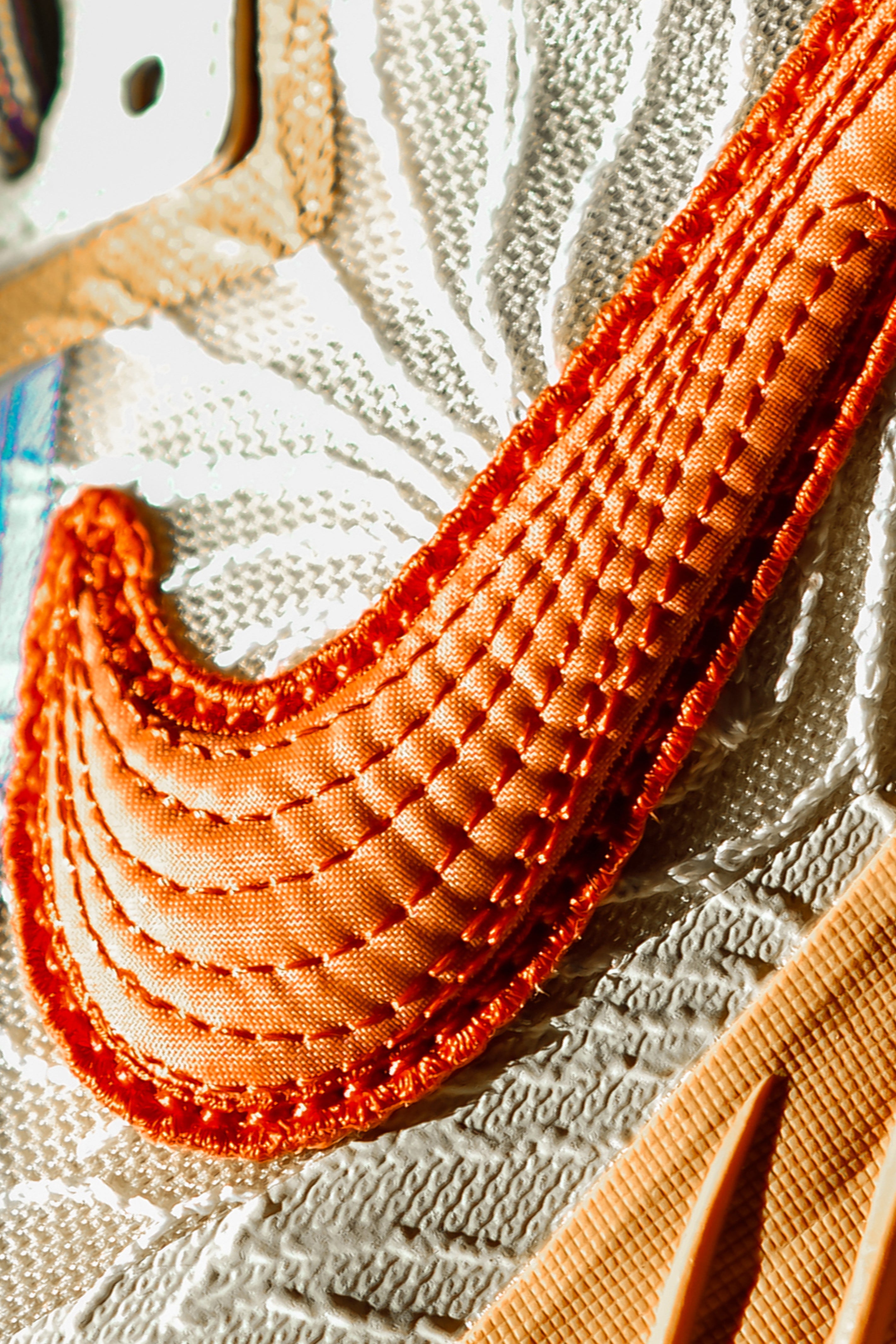 Close-up of a textured stitched shoe detail on a textured surface of a basketball sneaker